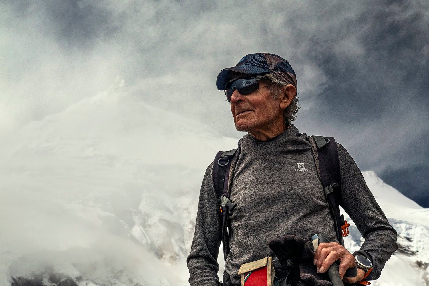 Carlos Soria con gorra y gafas de sol frente a una montaña nevada